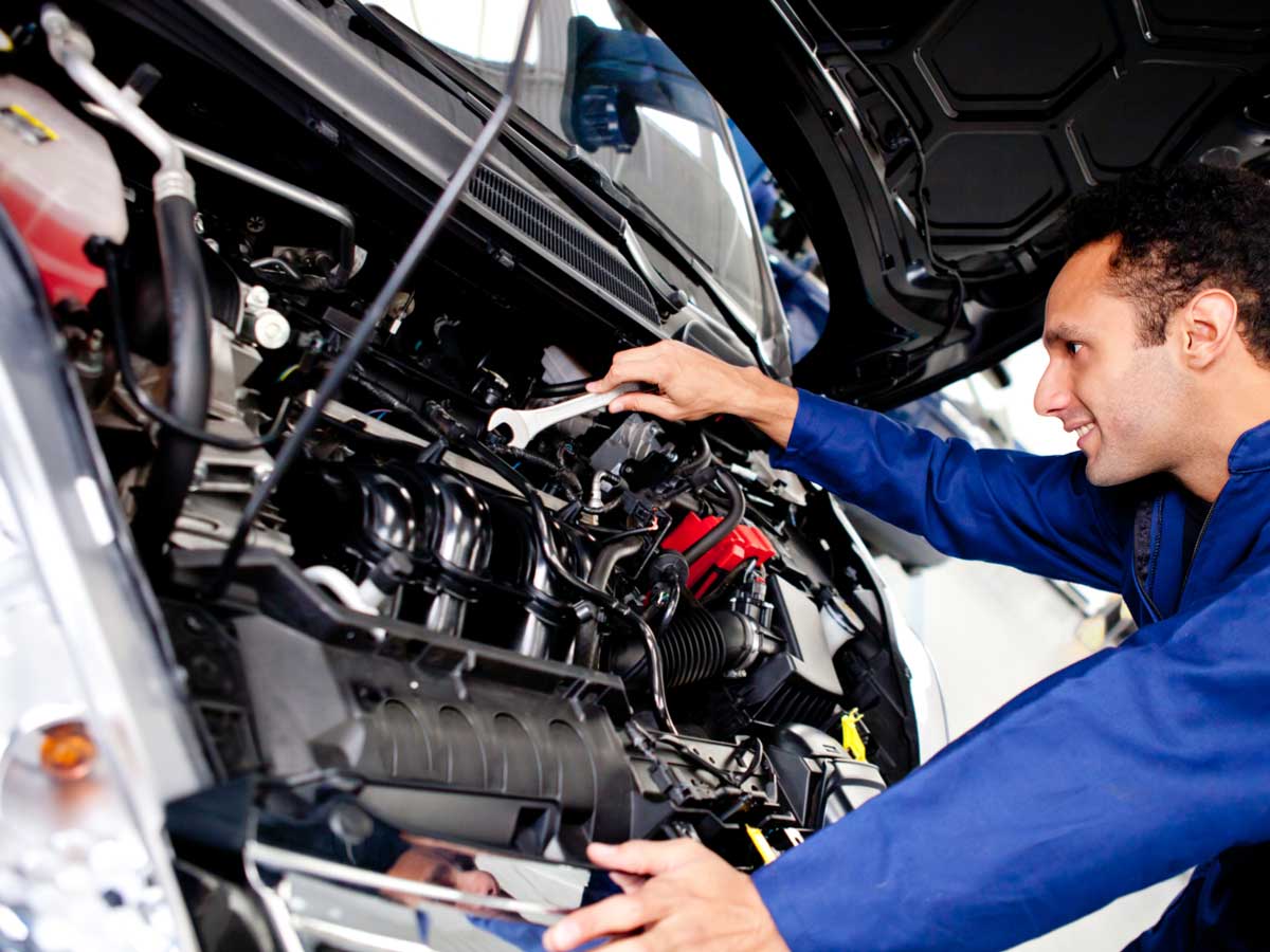 Mecánico realizando mantenimiento en el motor de un coche en el taller multimarca Autopasa en Barcelona